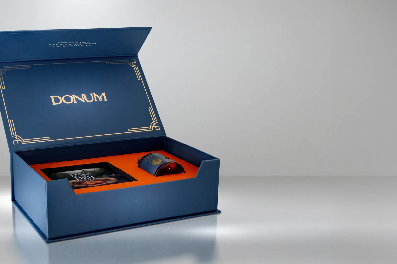 Die geöffnete Geschenkbox mit Booklet und eingelegtem Flakon